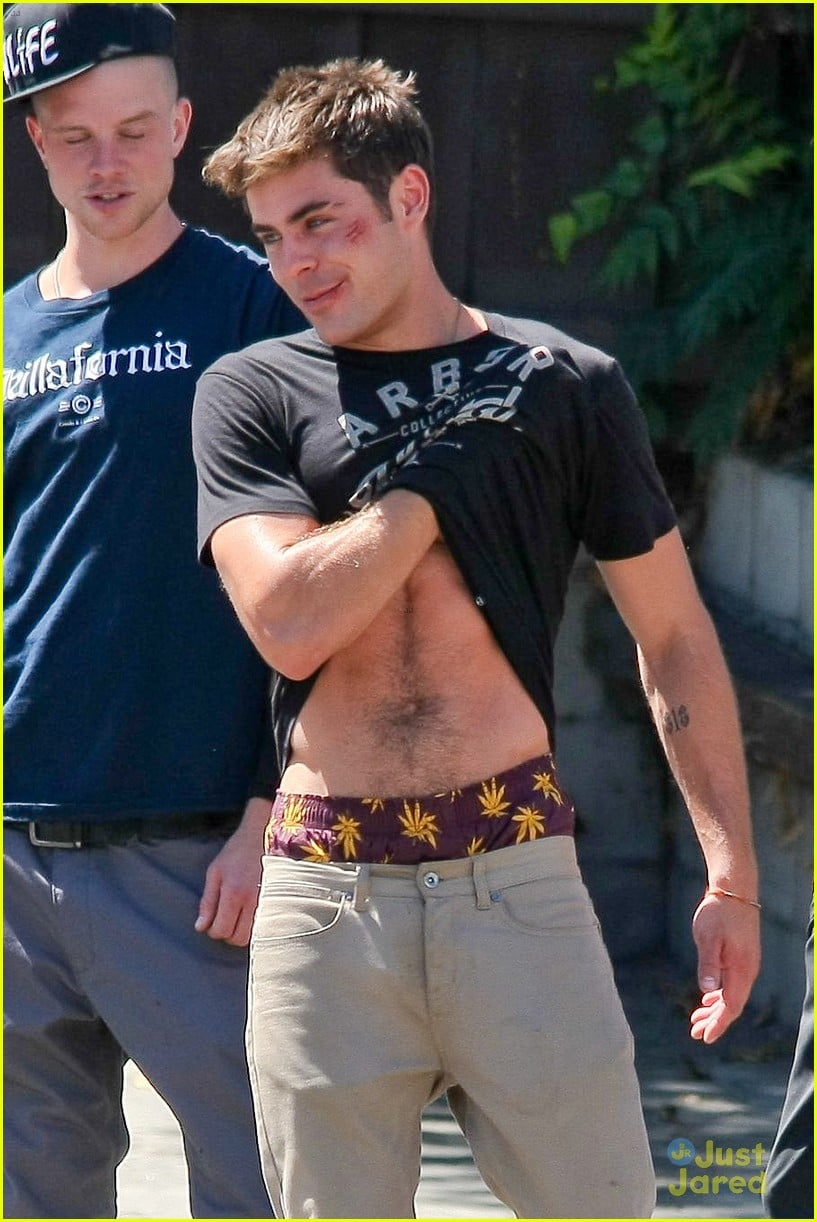 zac efron lifts up his shirt abs 02