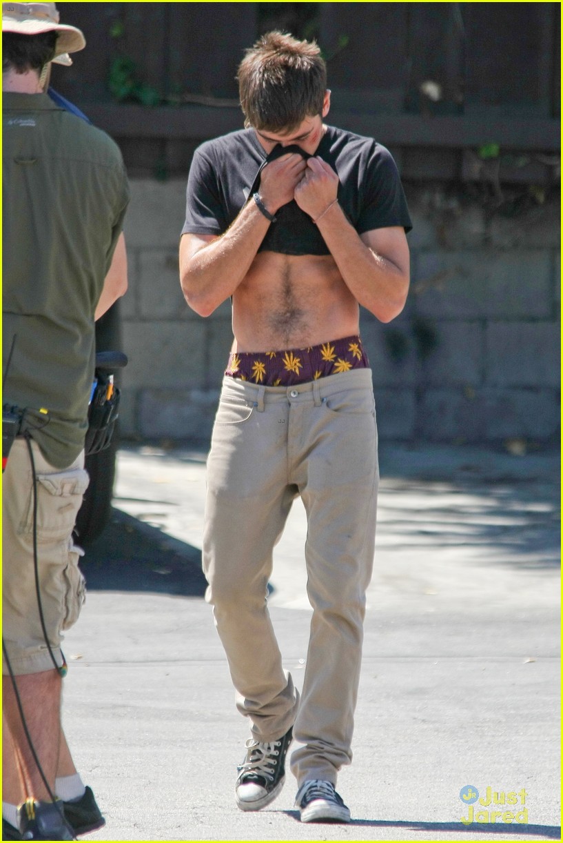 zac efron lifts up his shirt abs 03
