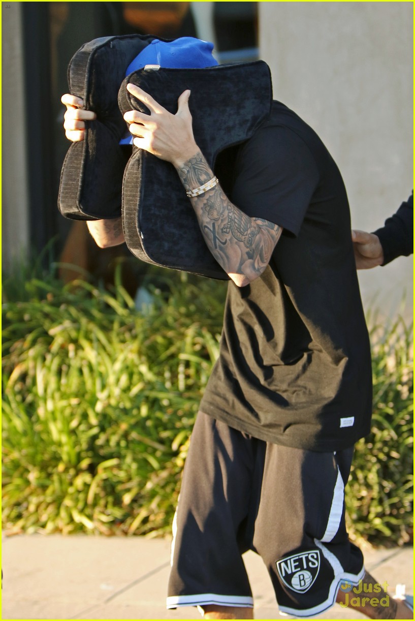 justin bieber covers hair with two cushions after salon visit 04
