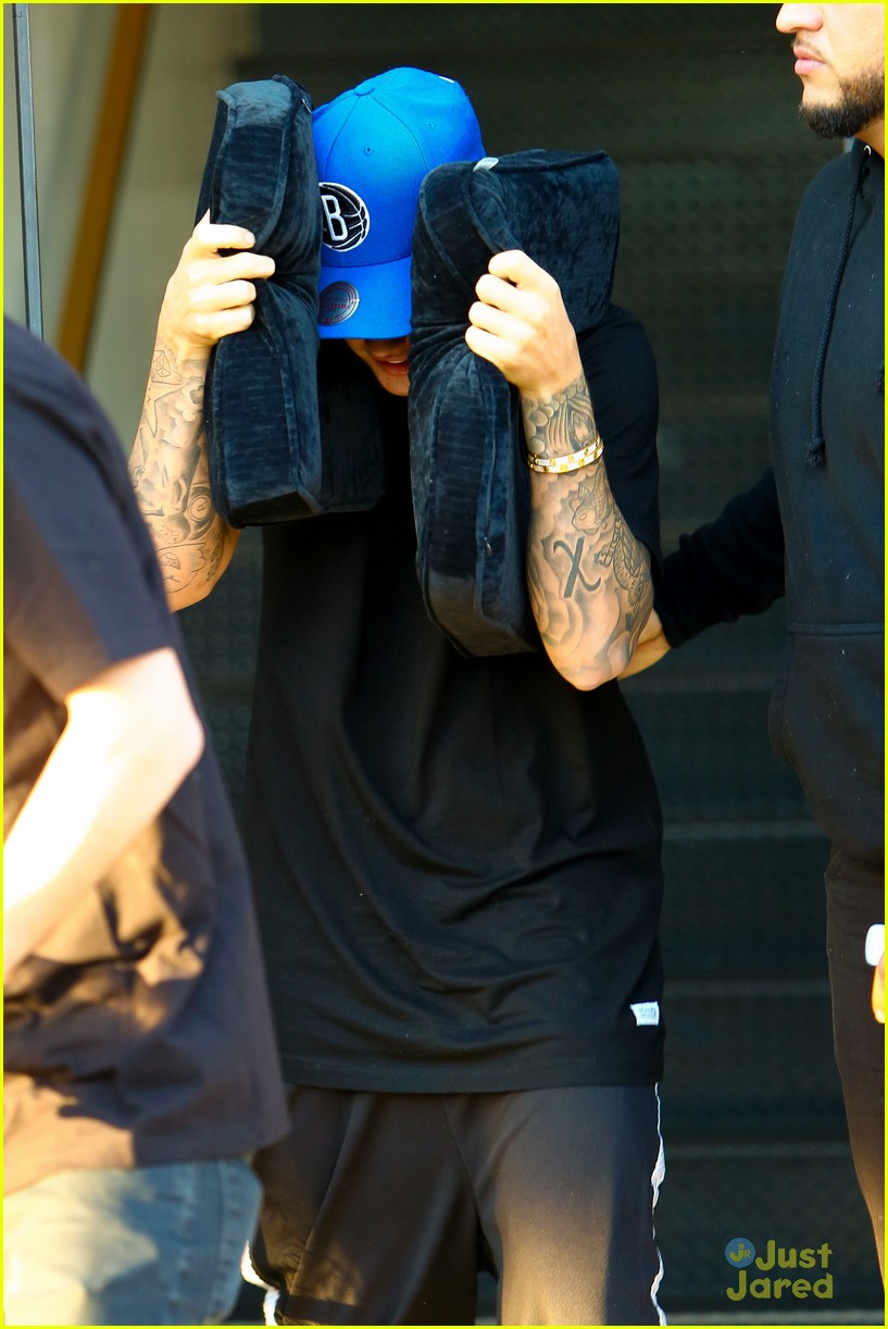 justin bieber covers hair with two cushions after salon visit 05