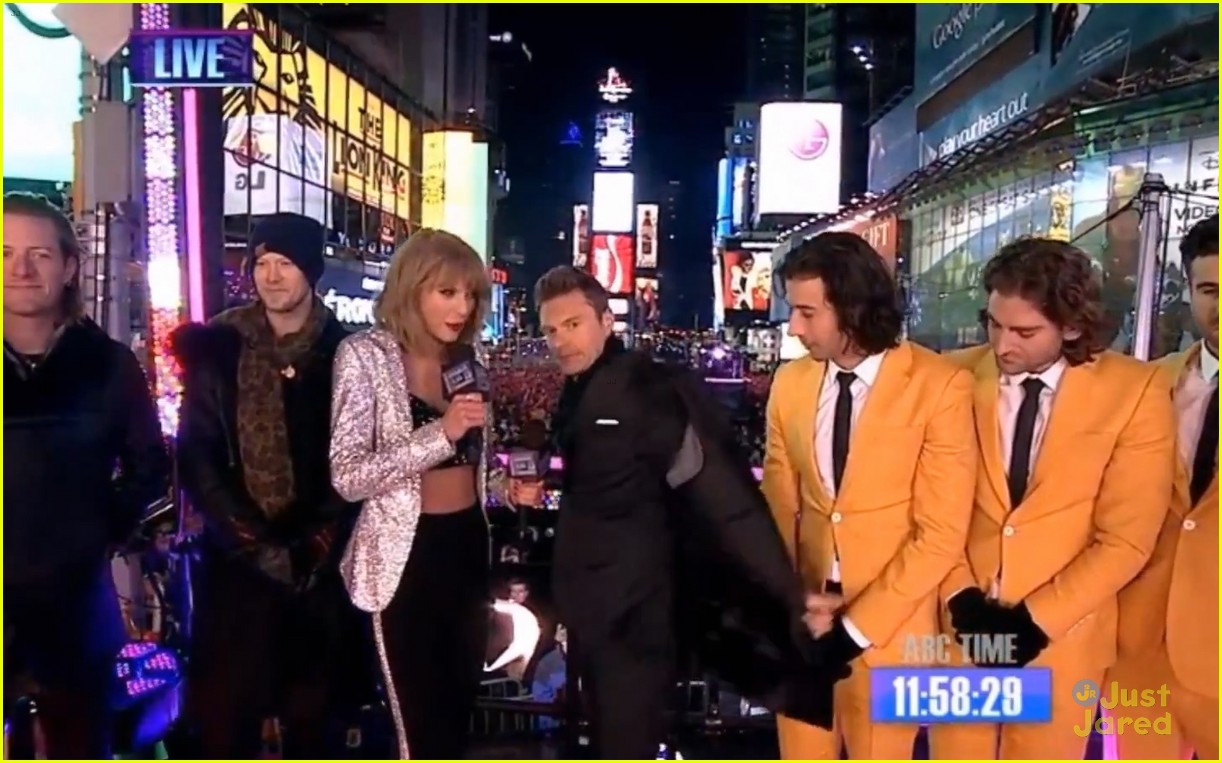 taylor swift warms up with ryan seacrests coat on new years eve 02