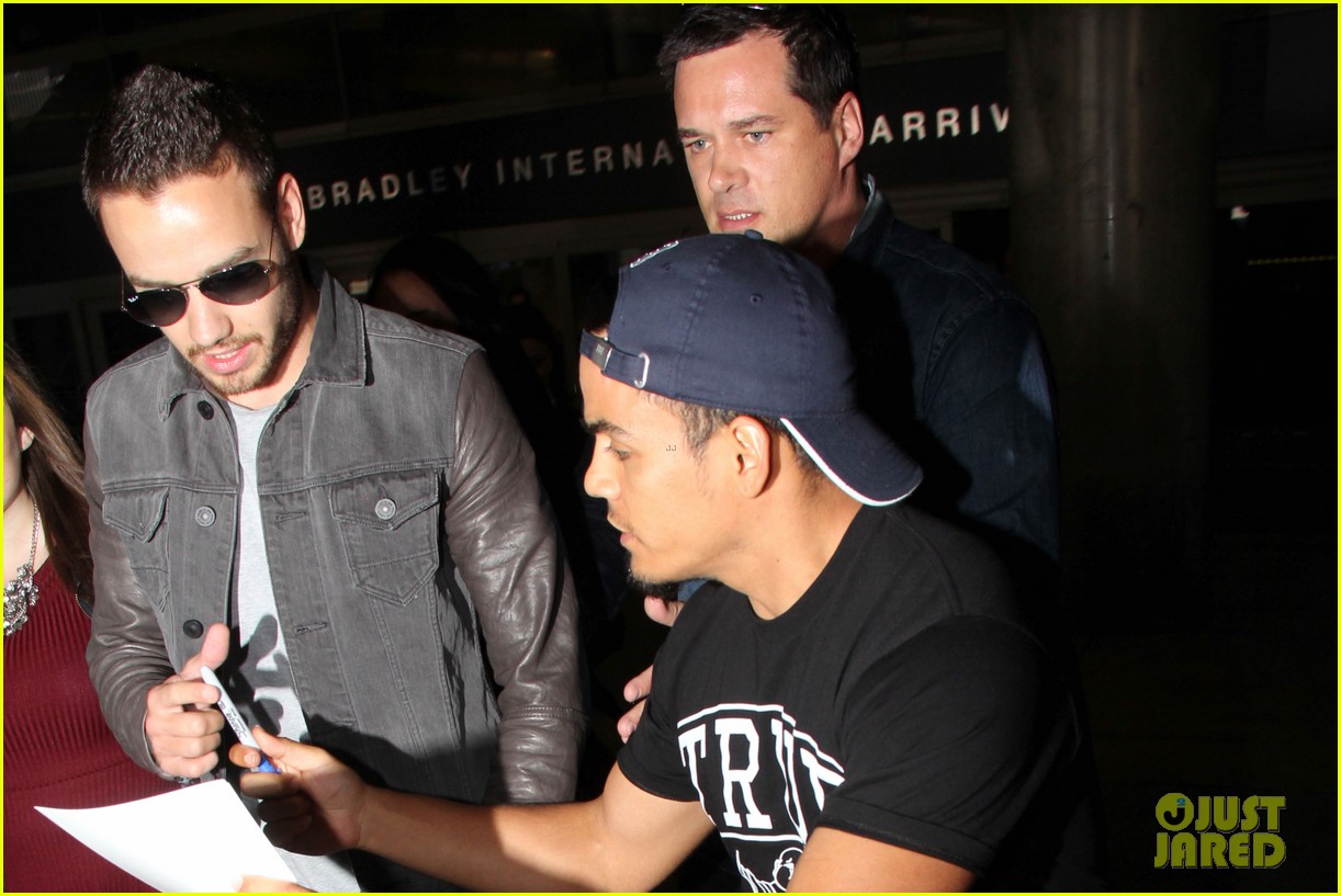 liam payne is bombareded by fans at airport 04