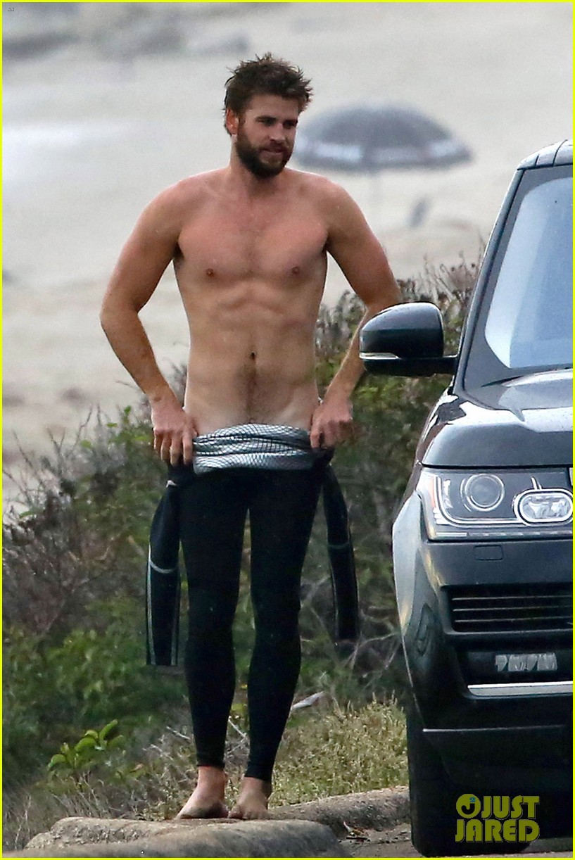 liam hemsworth bares his ripped abs while stripping out of wetsuit 01