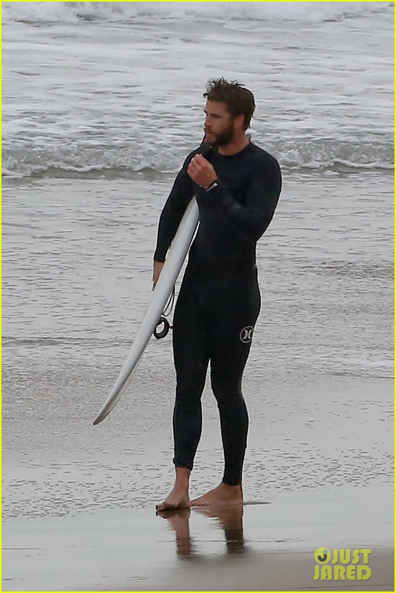 liam hemsworth bares his ripped abs while stripping out of wetsuit 05