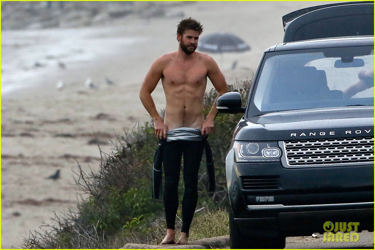 liam hemsworth bares his ripped abs while stripping out of wetsuit 12