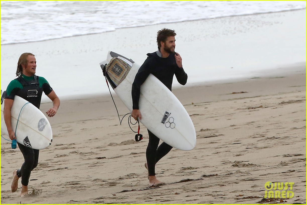 liam hemsworth bares his ripped abs while stripping out of wetsuit 13