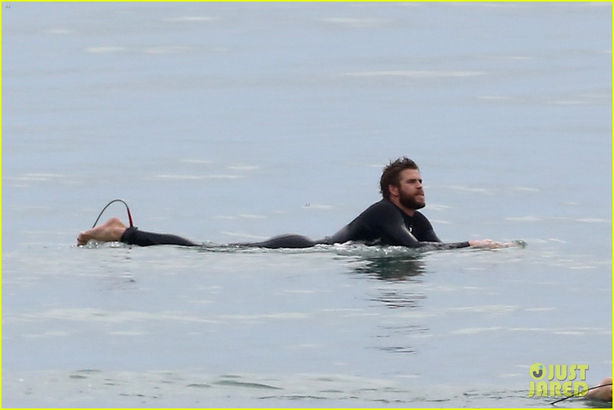 liam hemsworth bares his ripped abs while stripping out of wetsuit 16
