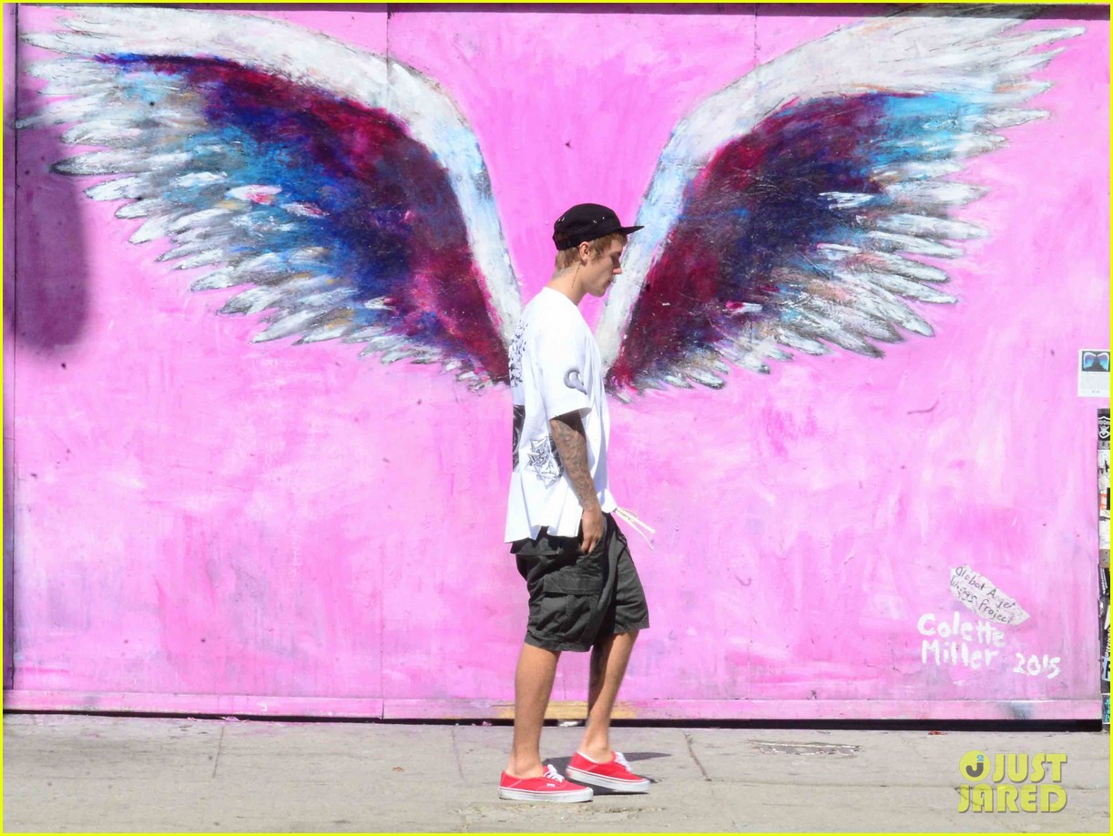 justin bieber walks by wings wall portrait at perfect time 03