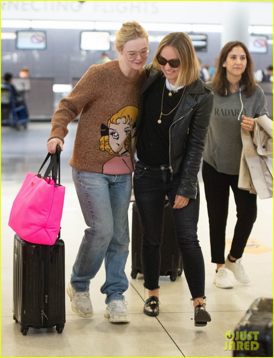 elle fanning and olivia wilde share a laugh at jfk airport with jason sudeikis08