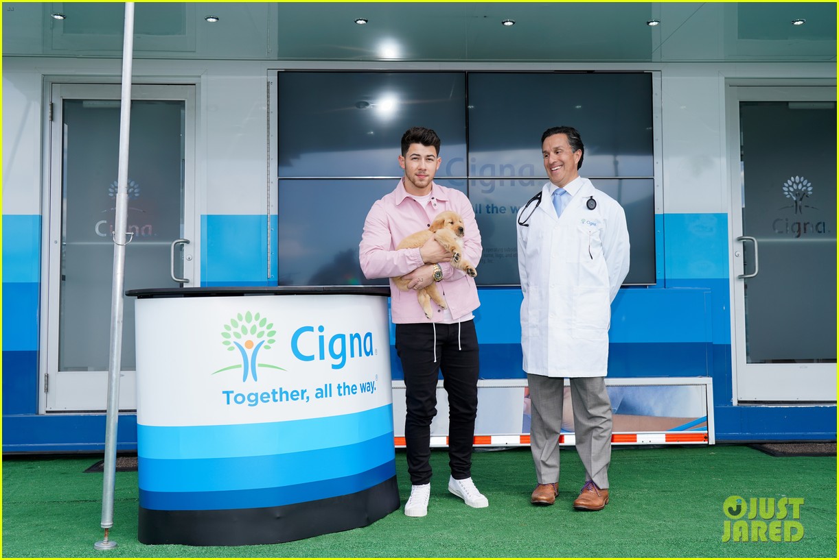 nick jonas cozies up to a puppy at cigna event 03