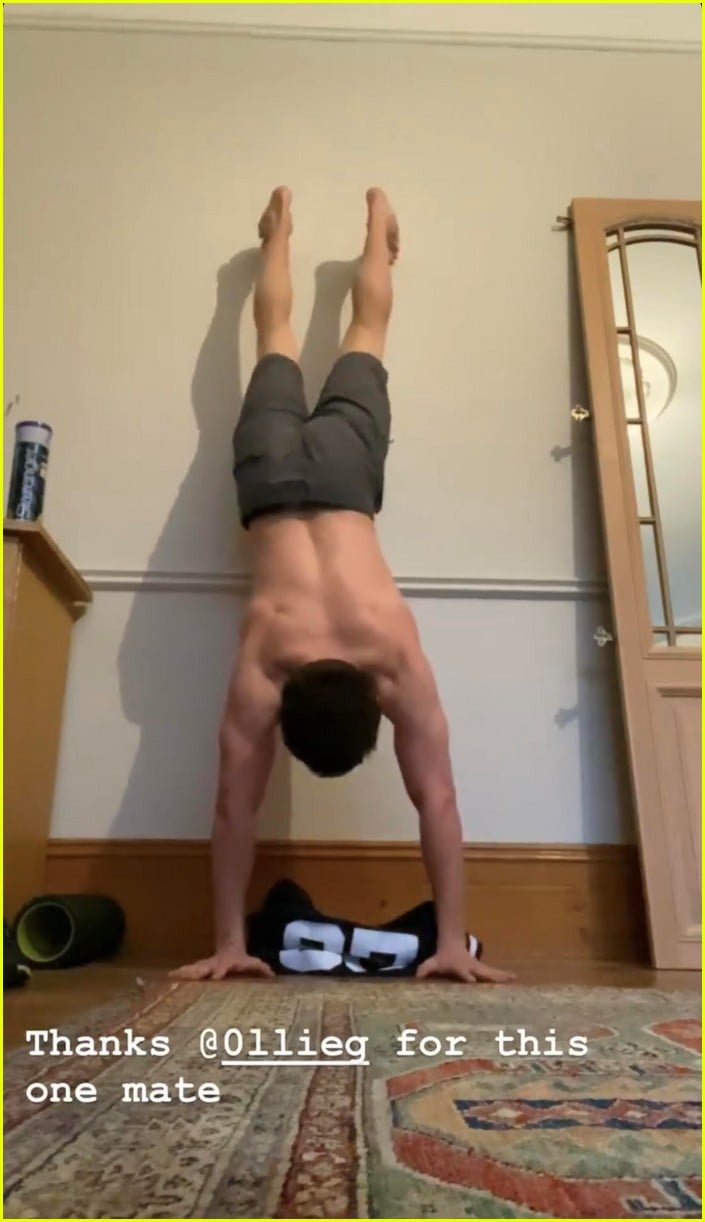 tom holland shows off muscular body while putting on a shirt while doing handstand 03