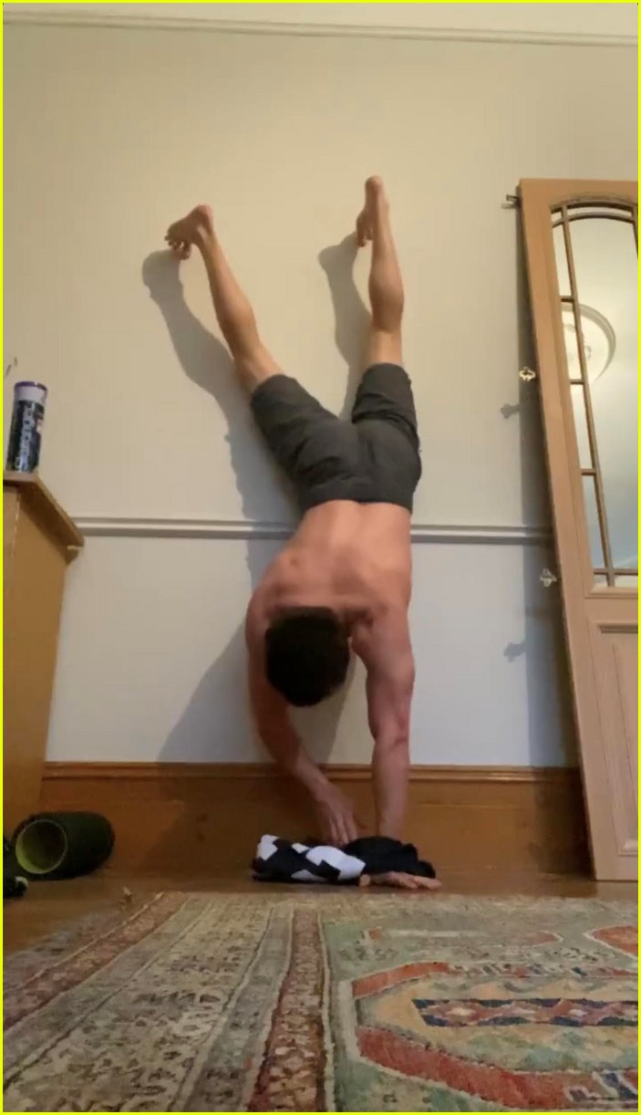 tom holland shows off muscular body while putting on a shirt while doing handstand 05