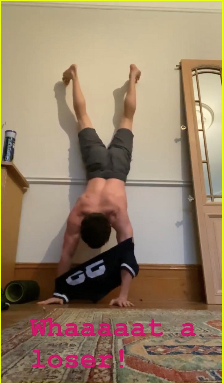 tom holland shows off muscular body while putting on a shirt while doing handstand 06