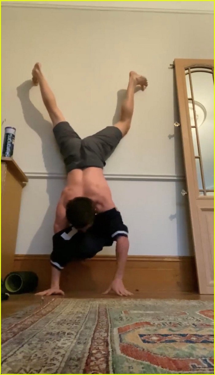 tom holland shows off muscular body while putting on a shirt while doing handstand 07