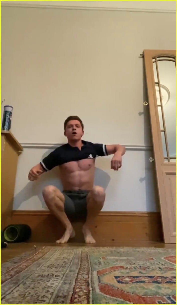 tom holland shows off muscular body while putting on a shirt while doing handstand 09
