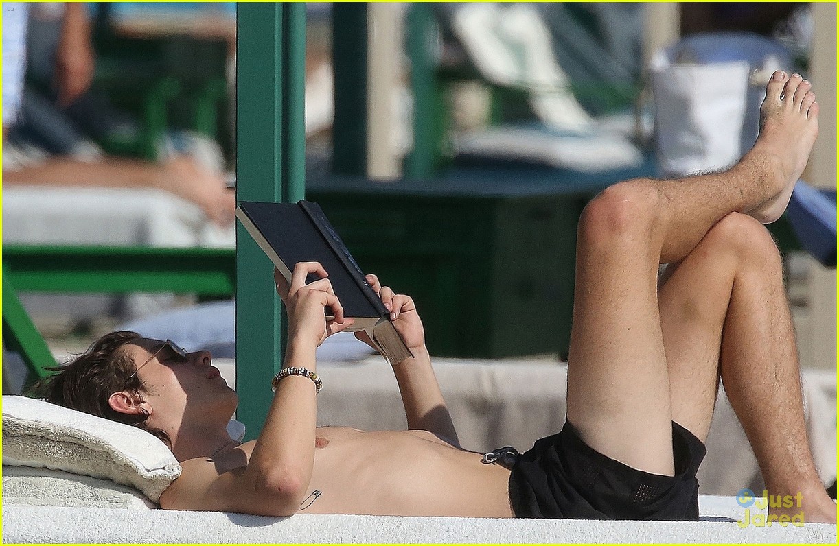 Louis Partridge goes for a dip in the water and reads a book on
